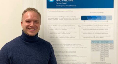 Yannick Metzler in front of a poster showing his research